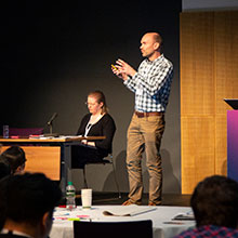 Someone giving a lecture standing on a stage.