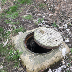 An open manhole at a potential sample site, thought to be the source of urban flooding here.