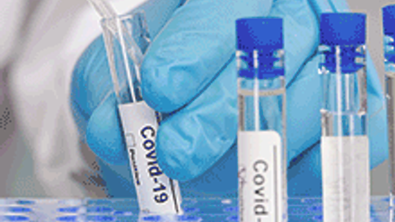 Hand in blue gloves, working with test tubes for Covid test