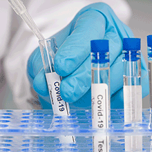Hand in blue gloves, working with test tubes for Covid test