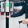 Person positioning their hand under alcohol gel distribution point