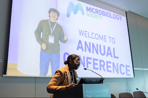 Society staff member presenting with 'Welcome to Conference' image in background