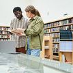 Students at a library talking about a book