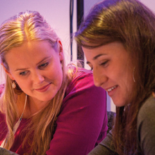 Two young women looking at a document
