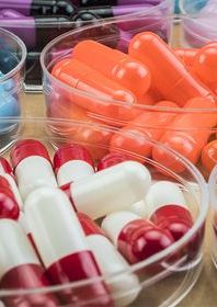 Close up picture of transparent bowls holding different colour pills