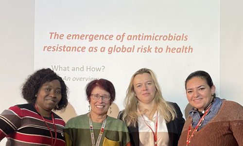 Four people stand in front of a slide reading 'The emergence of antimicrobials resistance as a global risk to health'