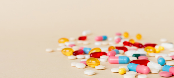 Various medications, set on a light pink background.