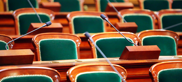 Collection of green and wooden seats with three speaker microphones.