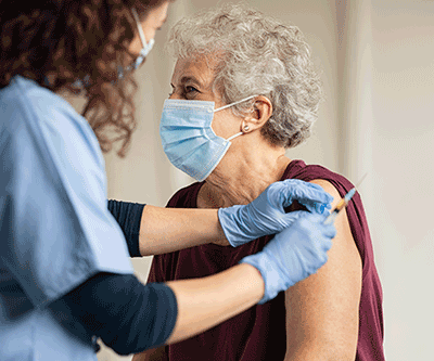 Old person wearing mask and getting vaccinated