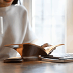 Person holding an open book on top of a table