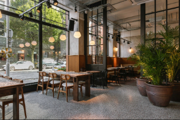 The inside of the Amelia Hall venue, showing tables, chairs and some plants.