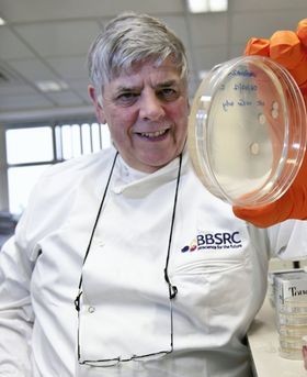 George Lomonossofft in a lab holding a petri dish.