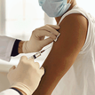 Close up picture of someone vaccinating another person in the arm